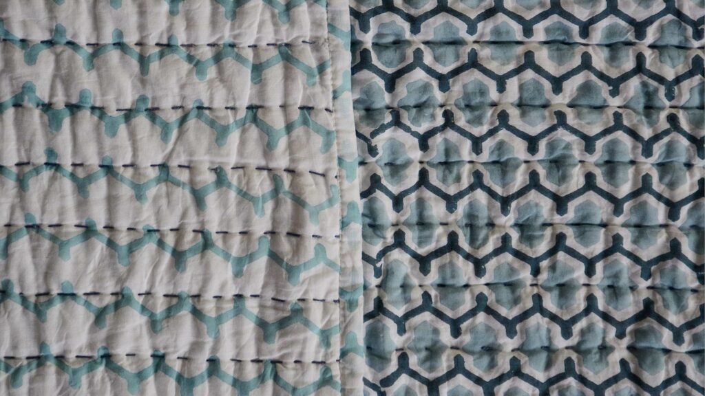 a close up view of the block print pattern and colours for this reversible light quilt