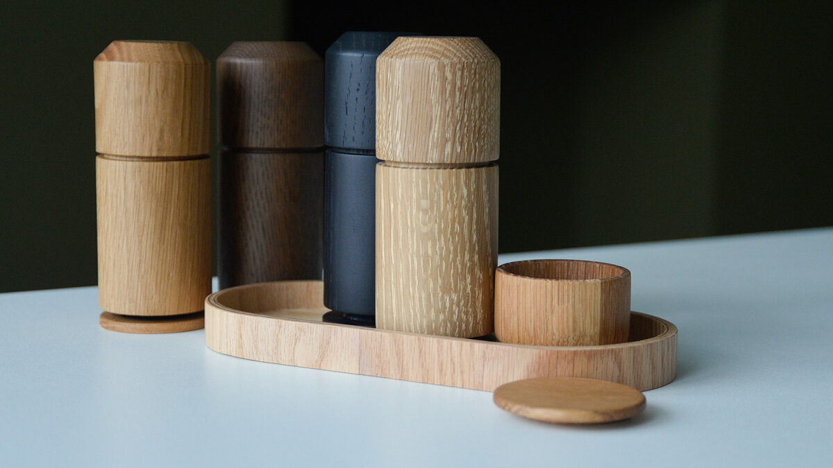 collection of wooden grinders with tray and salt pot