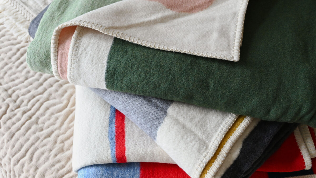 Stack of three neatly folded throw with abstract designs. Top down view.