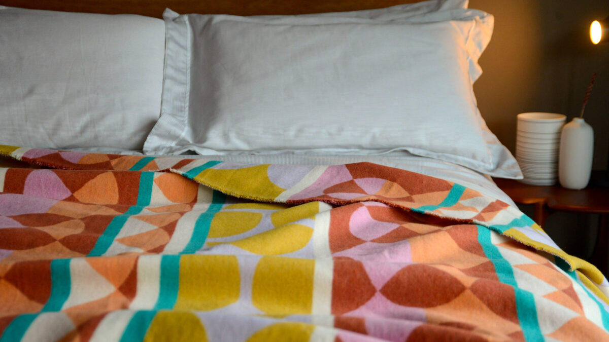 soft cotton throw in a pattern of muted coours including terracotta and mustard