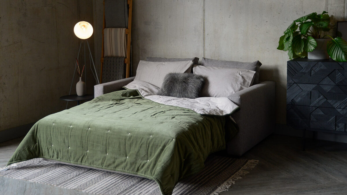 compact sofa bed dressed as a bed