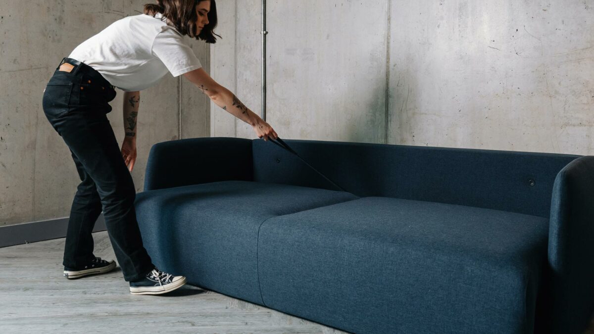 contemporary sofa bed being folded out to make a bed using the pull handle