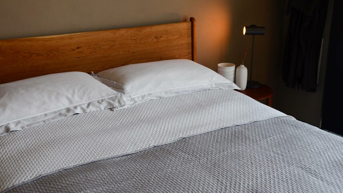 reversible stitched polka dot quilted bedspread in grey and white folded to show both sides