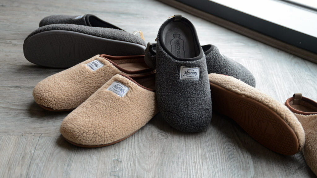 beige and grey sheepskin look slippers with solessustainably made from recycled bottles