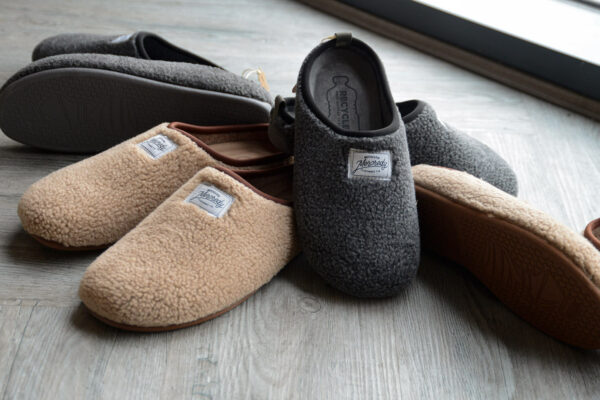 beige and grey sheepskin look slippers with solessustainably made from recycled bottles