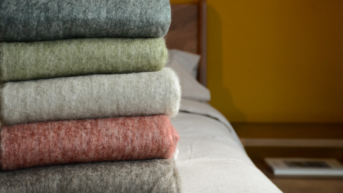 wool blend cosy autumn colour throws with white fringes a picture of them stacked together