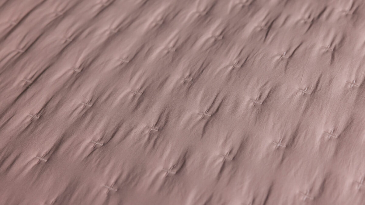 cross embroidery on blush pink bedspread