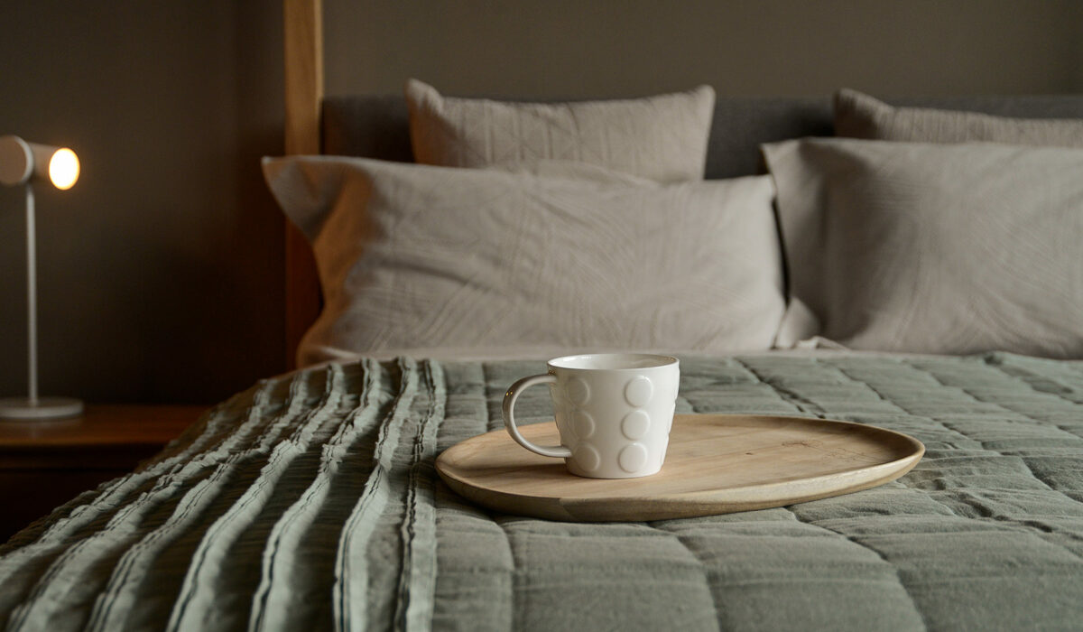 linen ruffle edge throw in Sage green shown on a bed