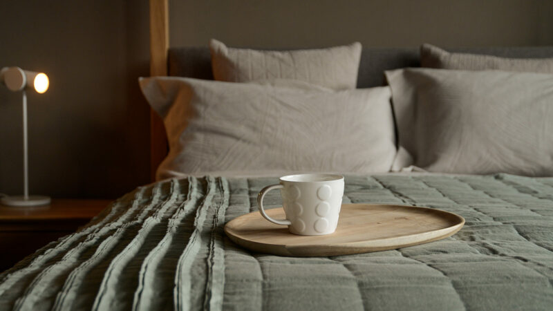 linen ruffle edge throw in Sage green shown on a bed