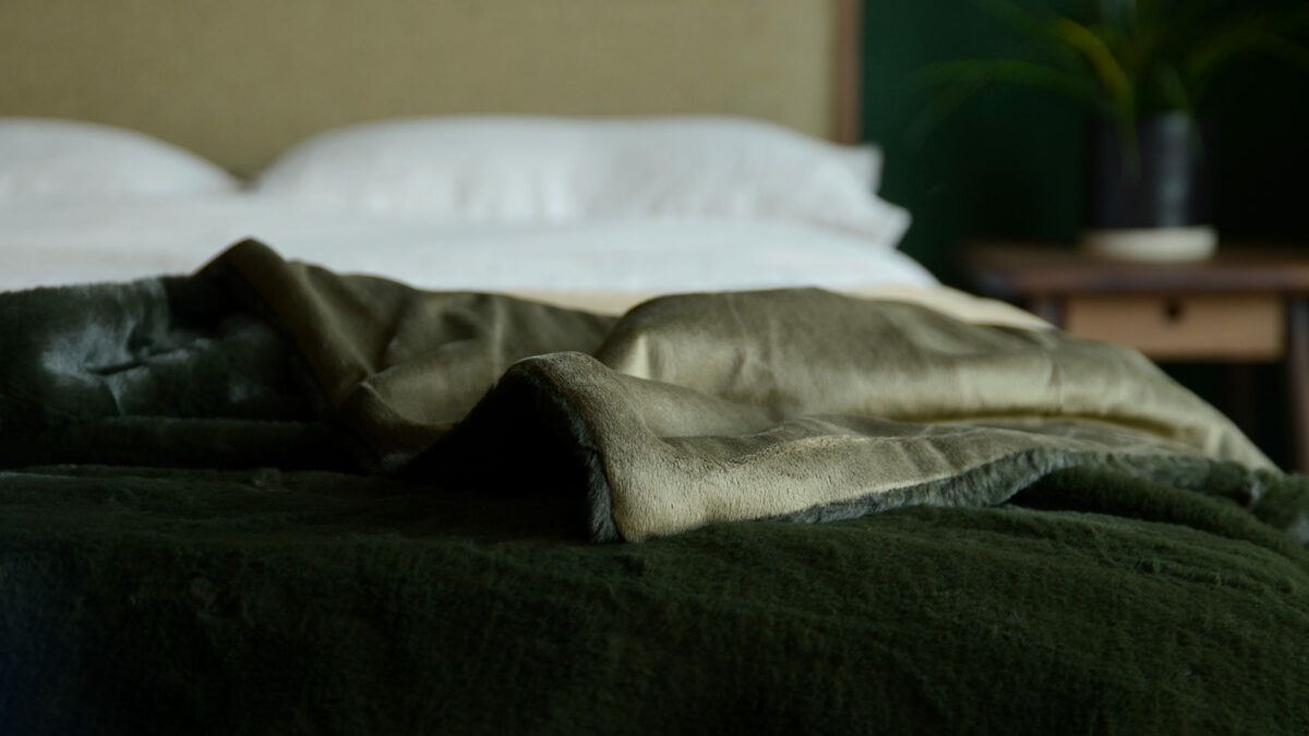 a closer view of our softest faux fur bed throw in deep olive green