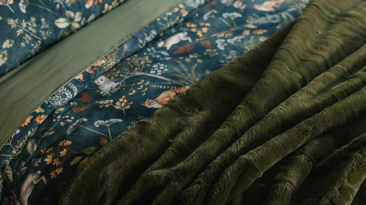Dark green duvet cover and pillowcase set with a nature print of foxes, plants, and owls