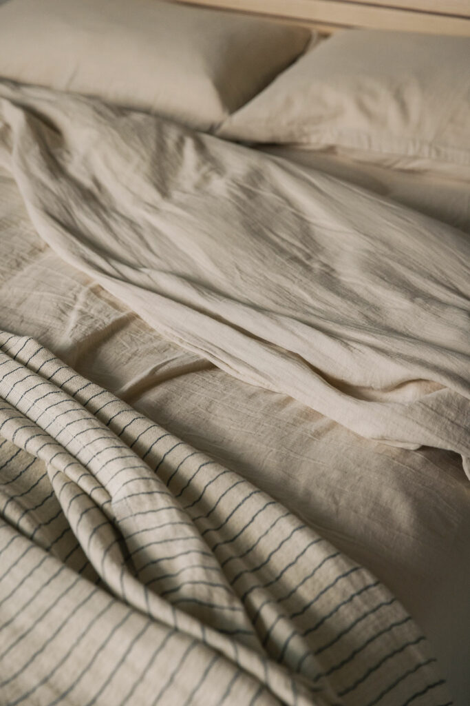 stone coloured muslin like bedding shown on a bed