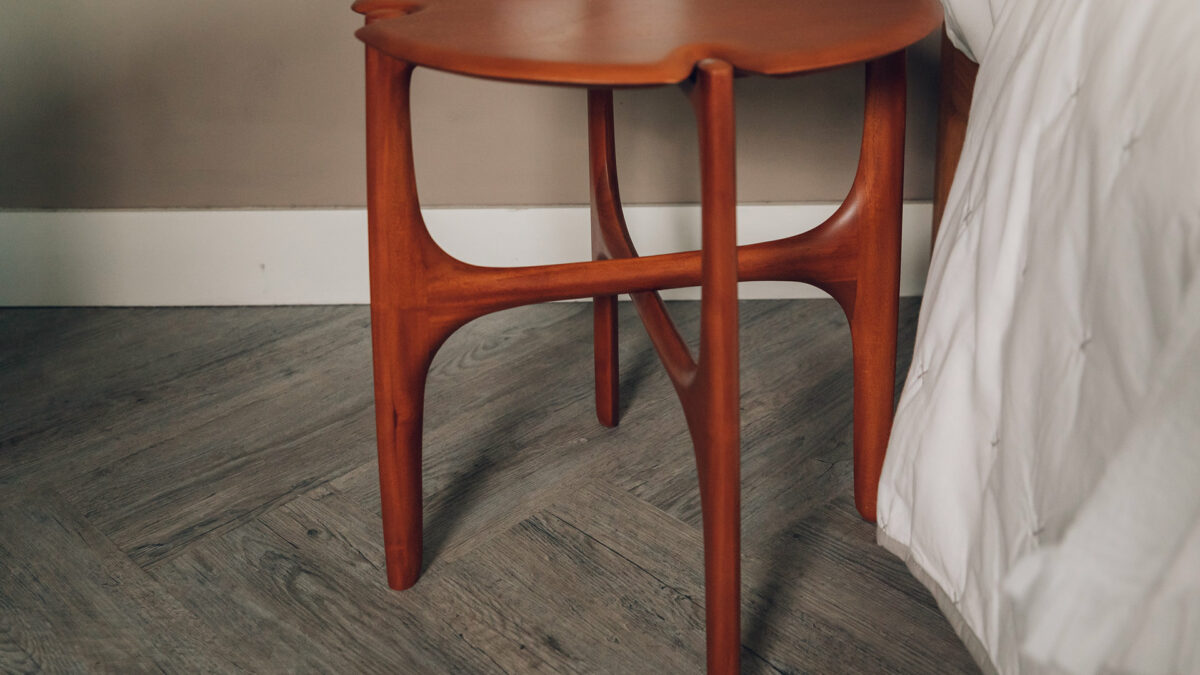 deep rich red mahogany side table with crossing legs and curved details