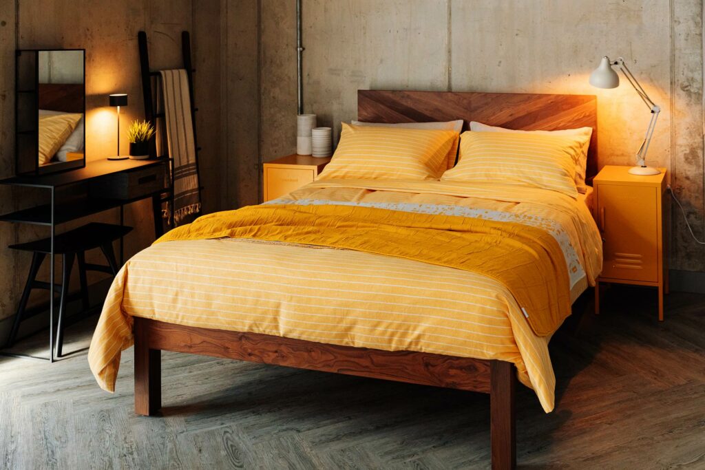 sunny yellow bedding shown on our solid walnut wood Hathersage wooden bed