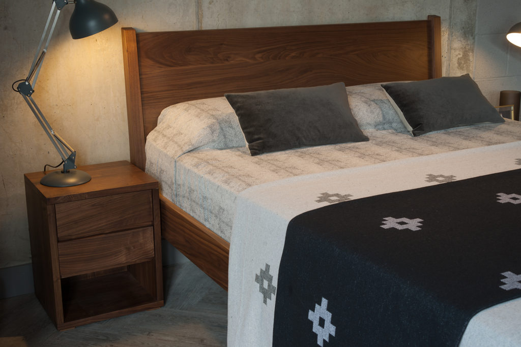 A view of the headboard of our walnut Zanskar bed shown with 2 drawer cube bedside table.