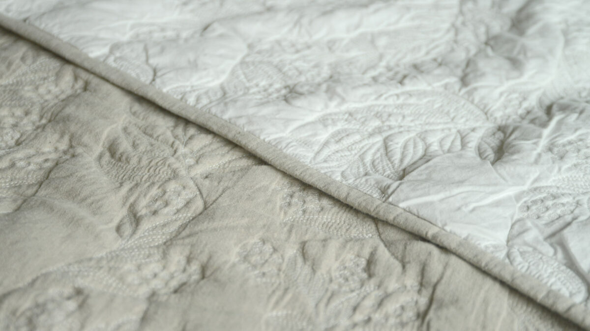 Reversible stitched and quilted bedspread ivory one side beige the other shown close up