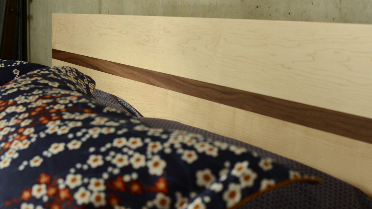 detail shot of our Tibet wooden bed headboard in Maple with a Walnut stripe