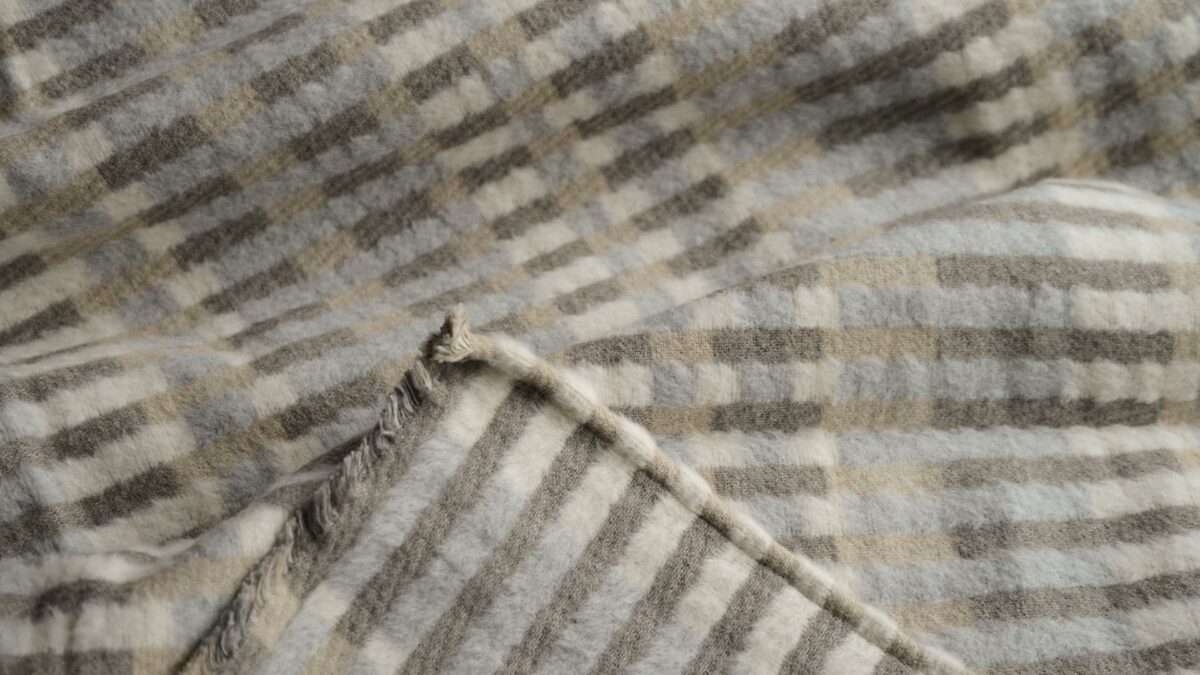 patterened stripey fluffy throw in ivory and taupe tones shown close up