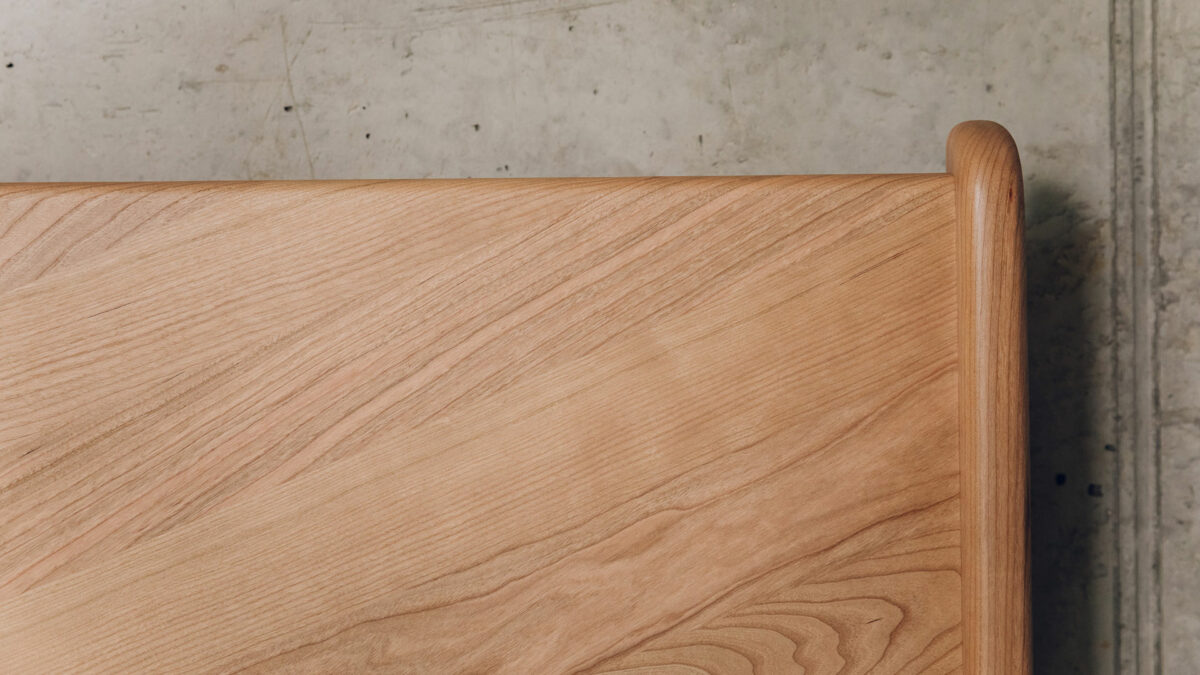 a close up view of the headboard of our mid century style cherry wood Hoxton bed