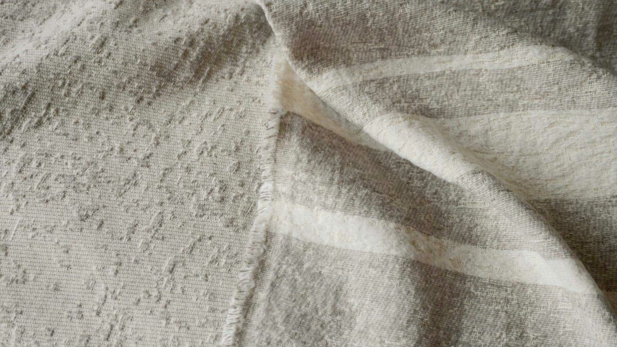 Cotton rich textured bedspread in ecru and ivory shown close up