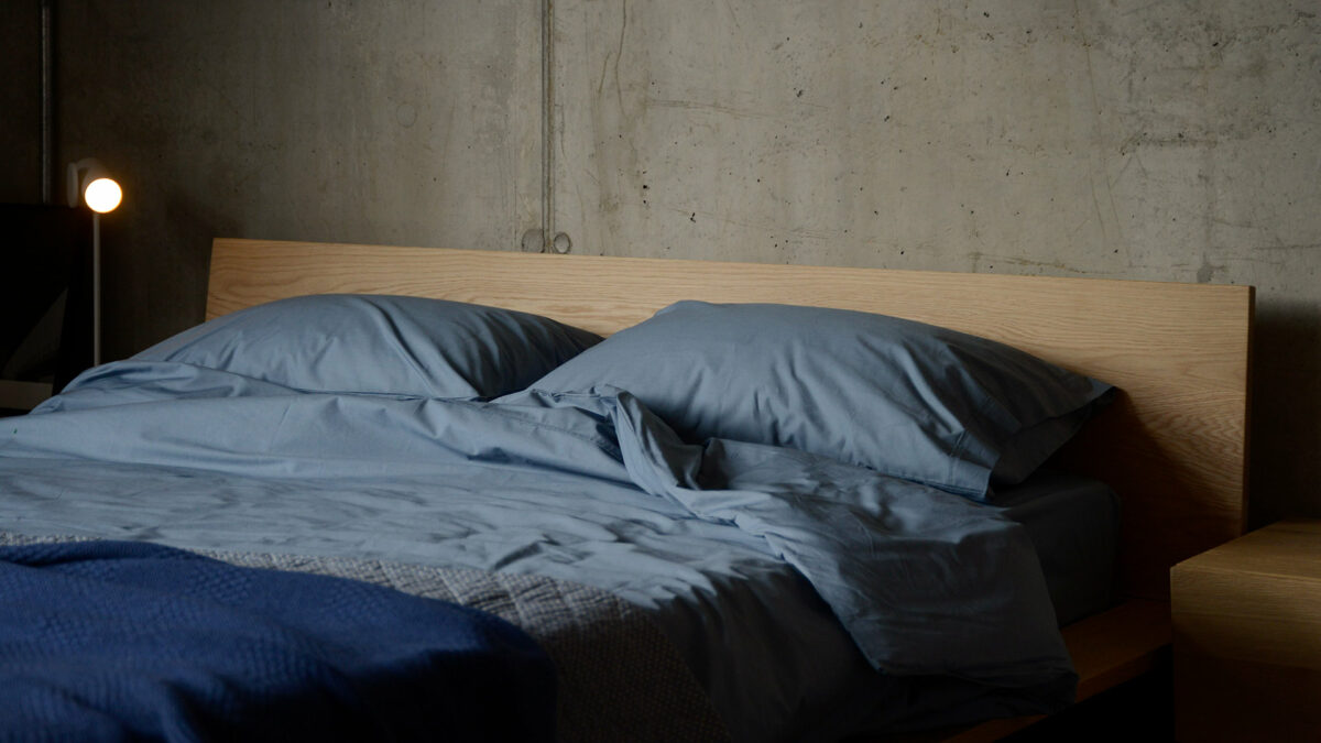 Egyptian cotton bedding in storm blue shown on a bed