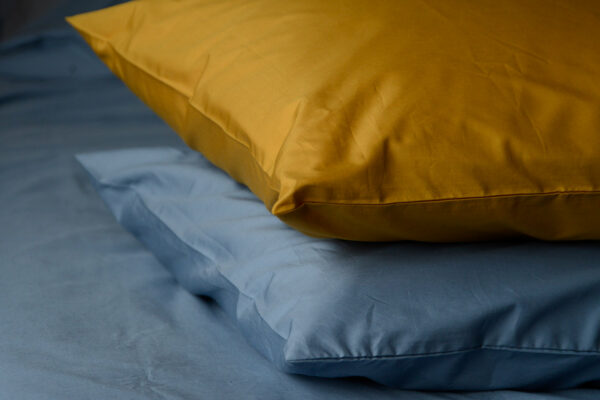 Egyptian cotton bedding available in ochre and storm blue shown together