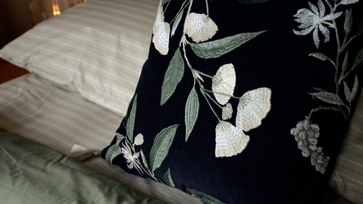 detail view of the floral embroidered black velvet cushion