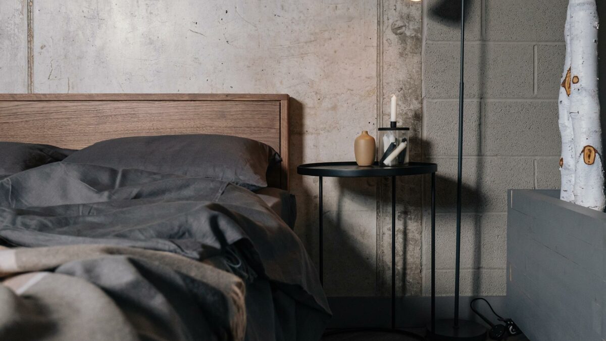 Black circular top side table used as a Bedside table with our Leith wooden bed