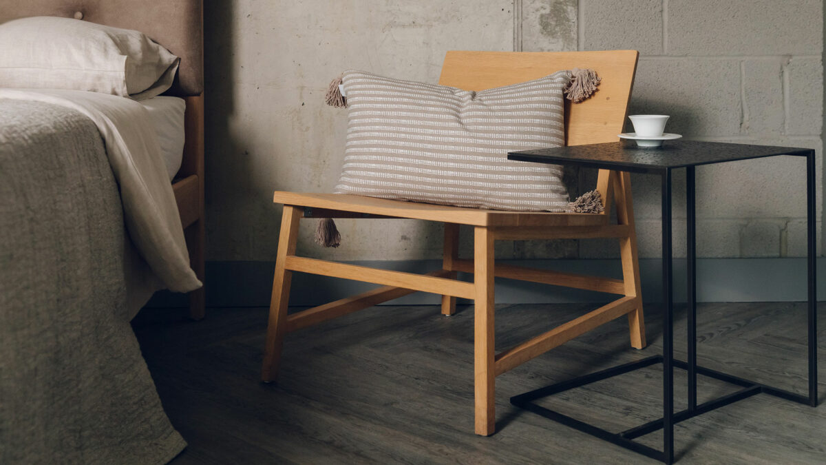 overhanging metal framed side table shown with an oak chair both by ethnicraft