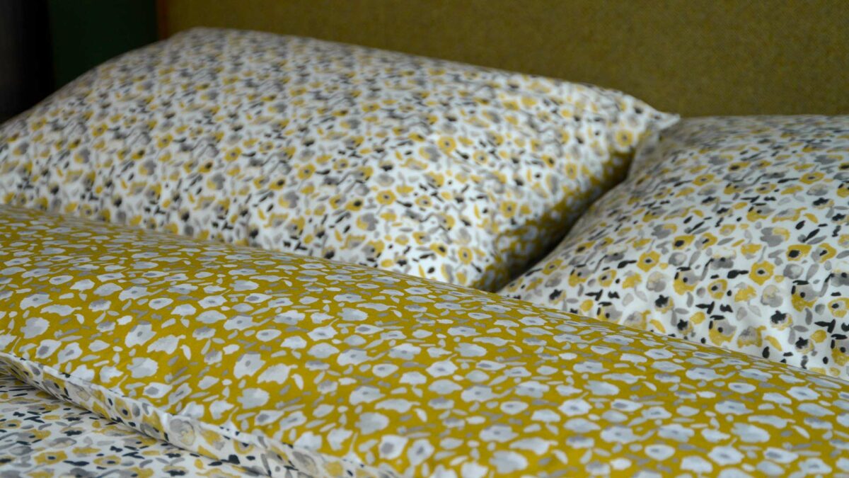 modern floral patterned reversible duvet cover set in yellow ochre and grey shown close up