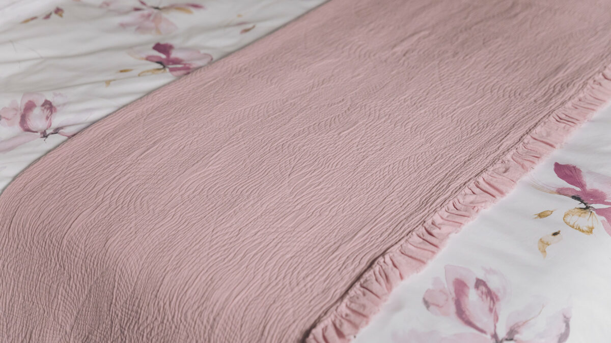folded pink ruffle bedspread