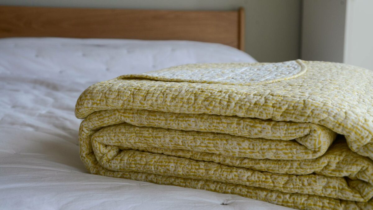 folded reversible bedspread in yellow