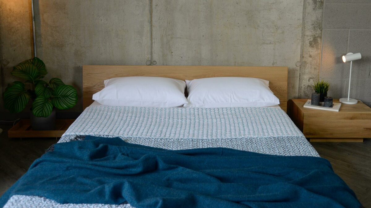 folded reversible hand printed blue bedspread on oak oregon with plant and madra table