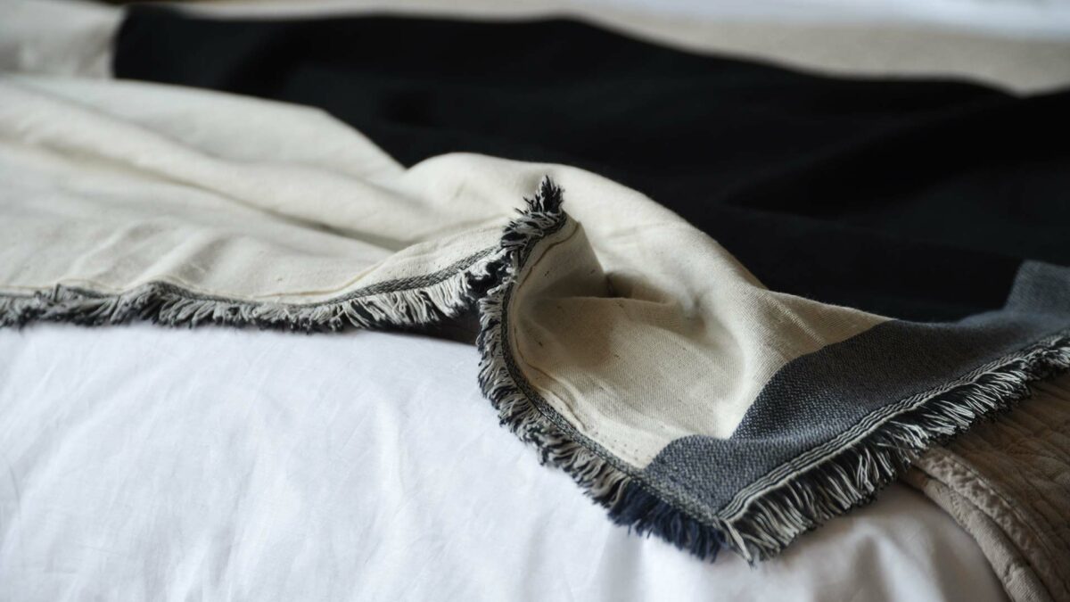 fringe edge to modern cotton blanket in ivory black and navy