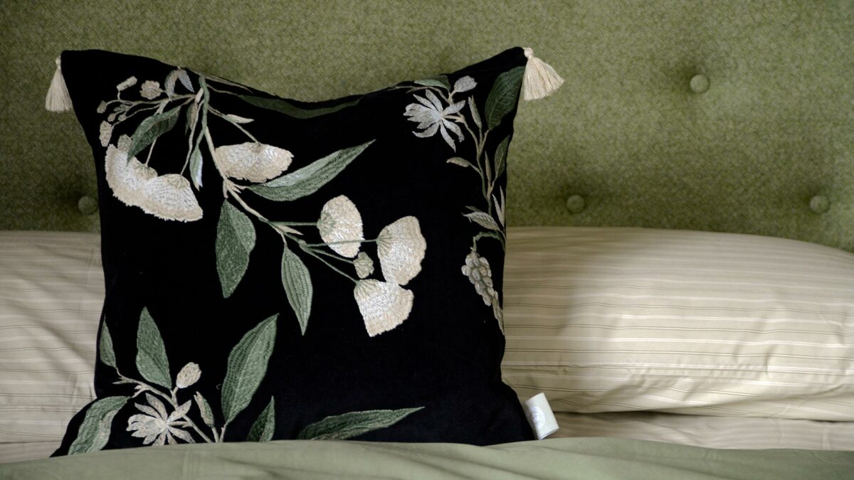 front view black velvet floral embroidered cushion with striped fitted sheet set