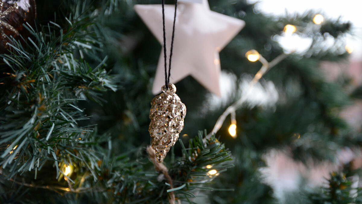 glittery gold Pine cone Christmas decorations hanging on a tree