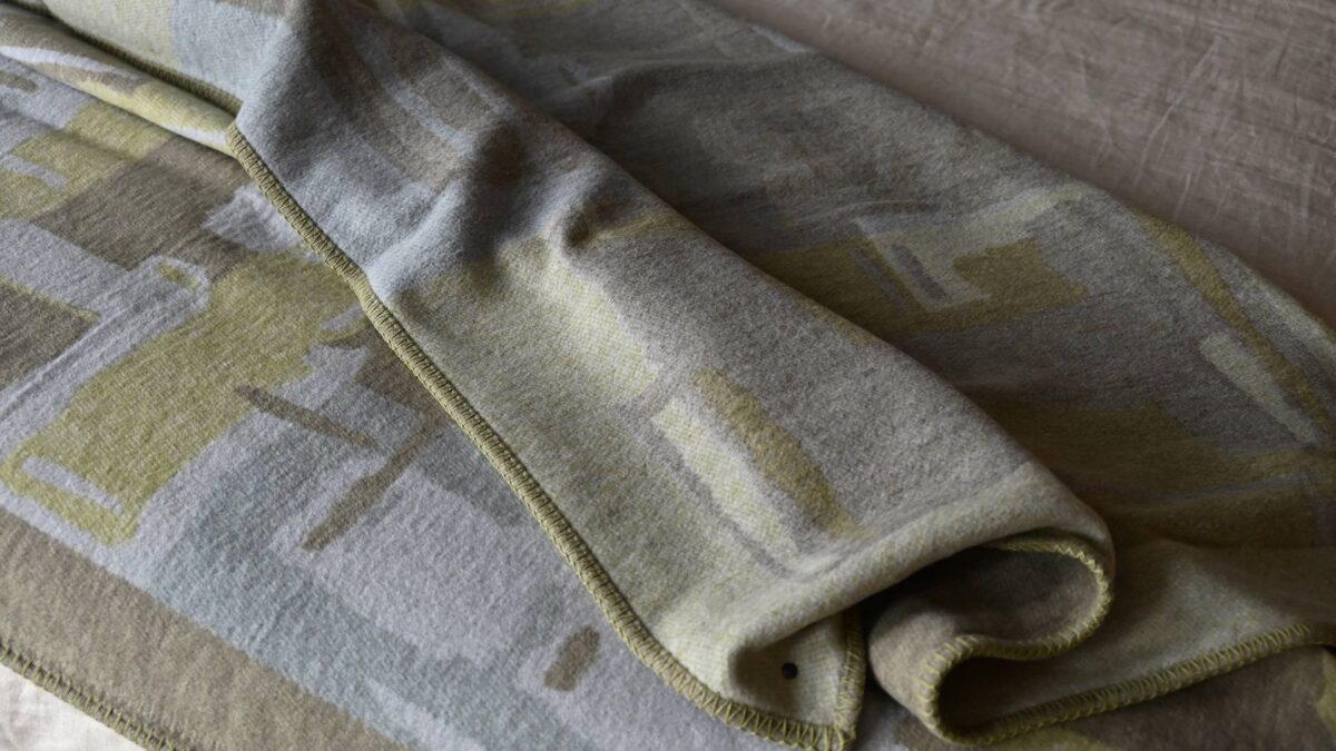 green, grey and taupe abstract patterned throw, closeup.