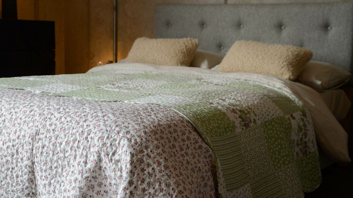 Reversible quilted bedspread in Sage and rose colours floral design one side and patchwork patterns the other