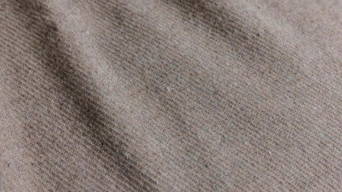 close up of a griege recycled merino throw.