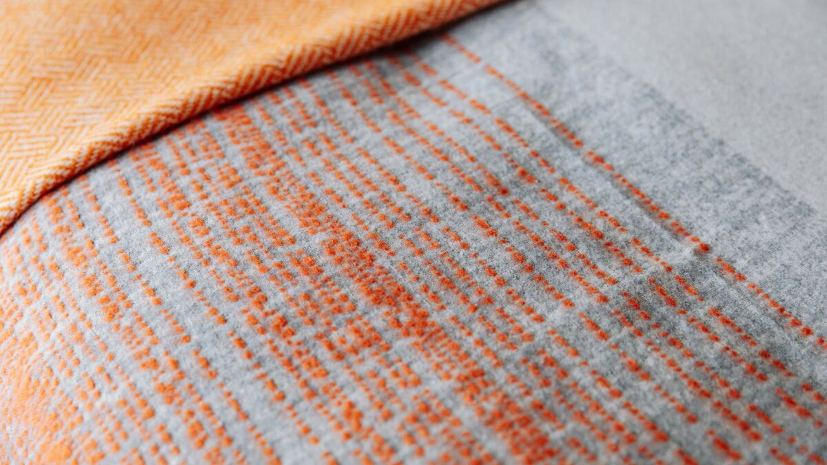 grey and deep orange patterned throw