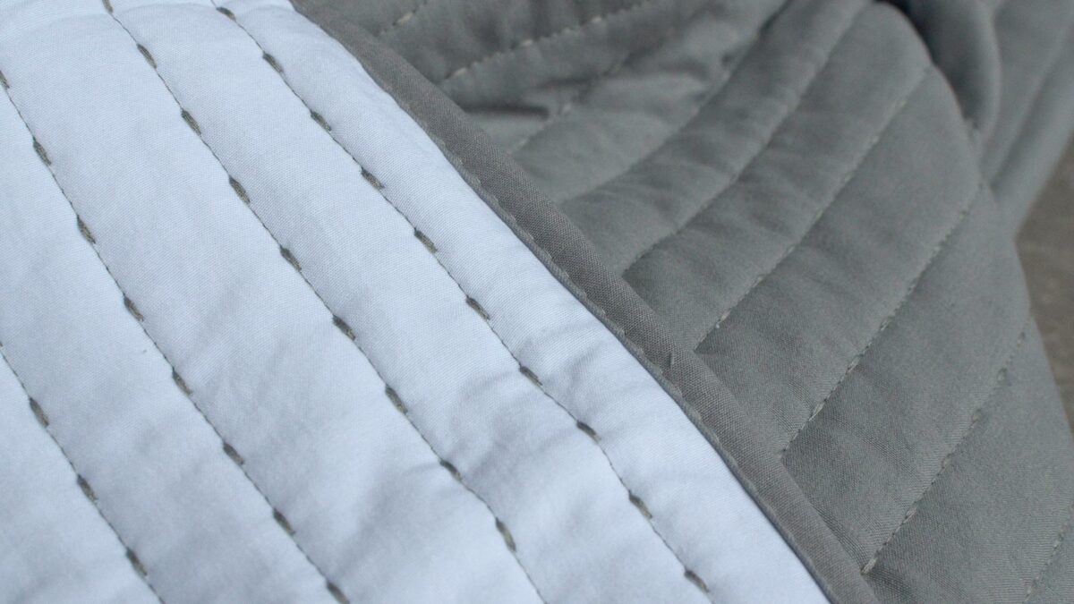 grey and white reversible stitched bedspread
