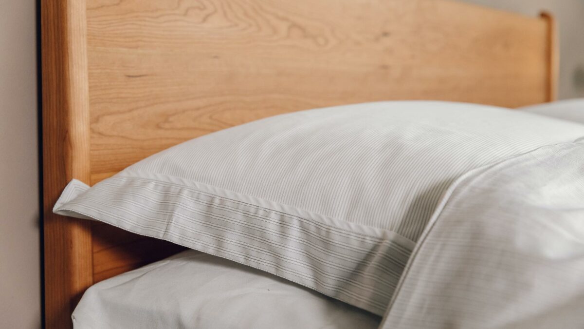 pale grey and ivory thin stripe duvet cover set shown in close up on a cherry wood Camden bed