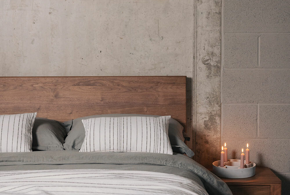 grey bedding on Chiswick bed with concrete ccandle holder portrait
