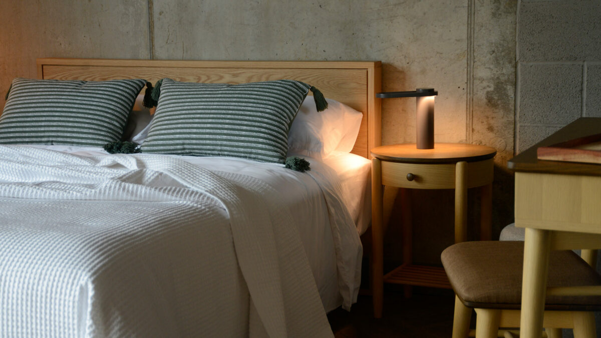 grey bedside lamp with green patterned cushions