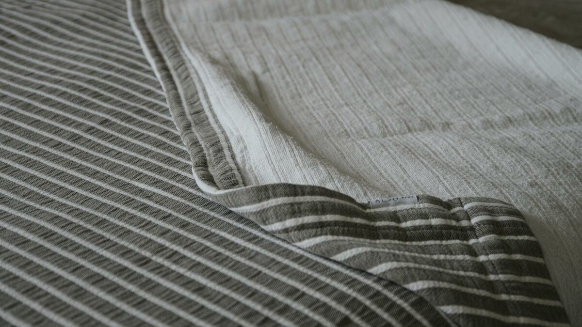 grey bedspread with ivory stripes detail