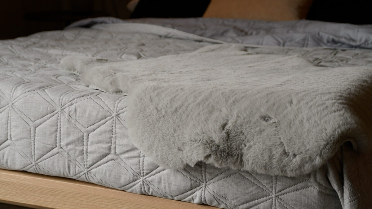 grey hexagonal quilted bedpread with faux fur throw