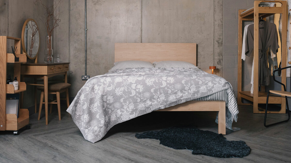 grey jacqaurd bedspread on maple solid wood bed with charcoal sheepskin