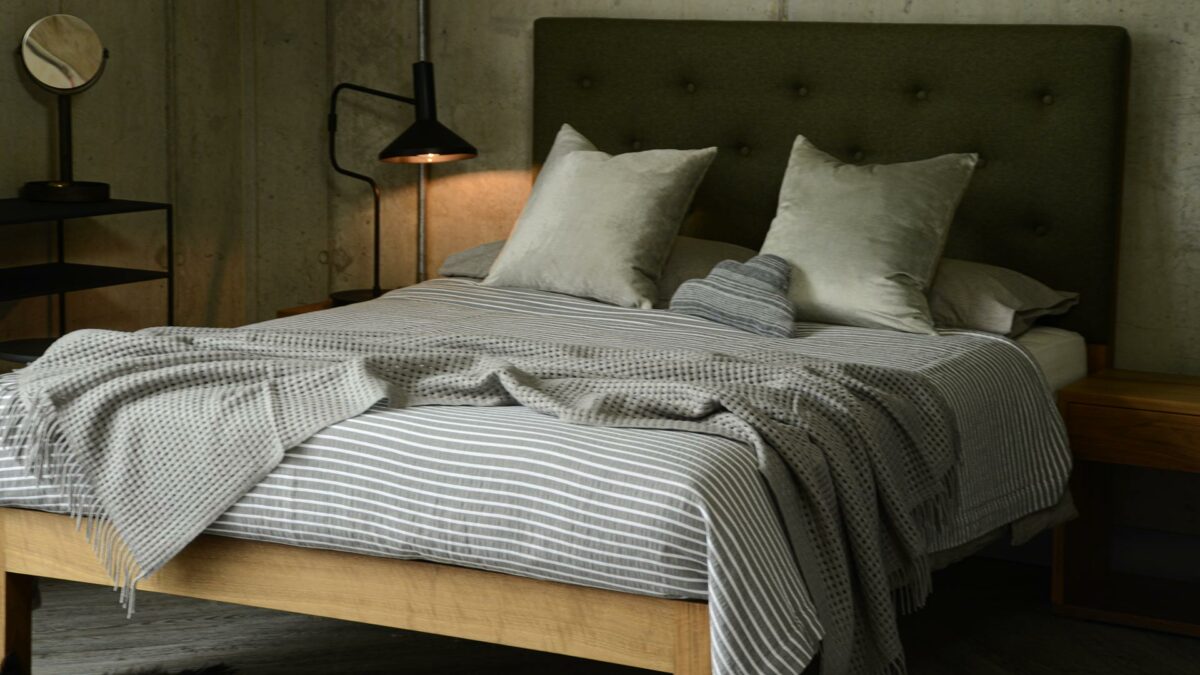 grey open weave throw with striped bedspread
