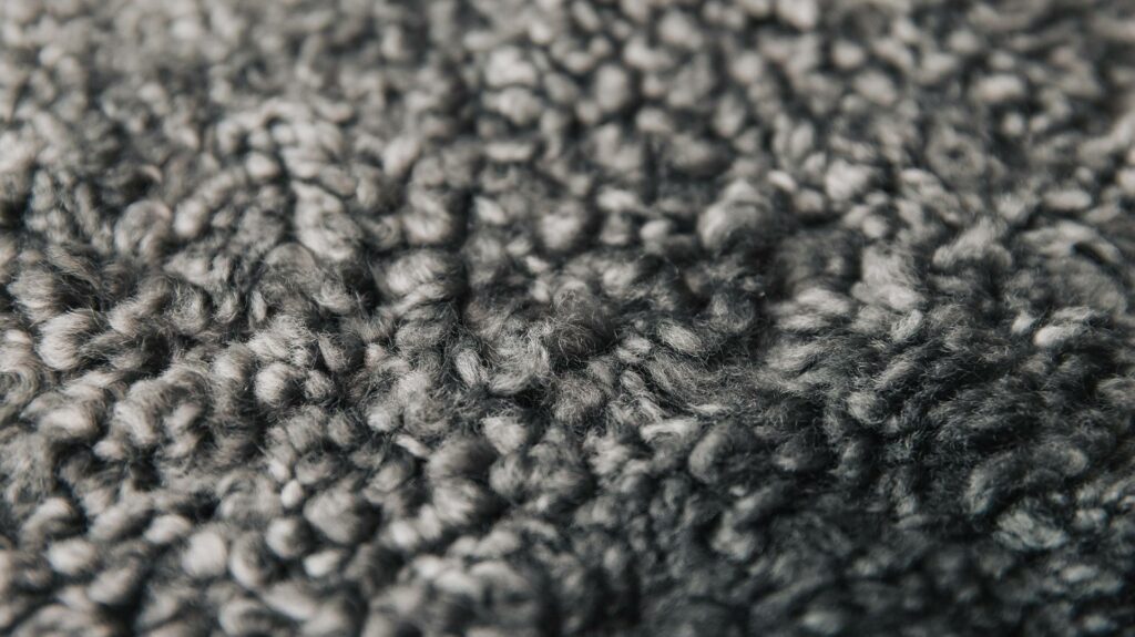 a close up of the short curly sheepskin in grey