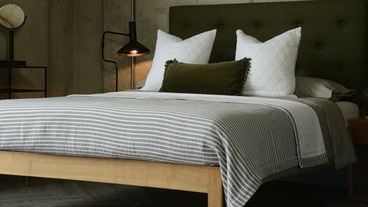 grey stripe bedspread with white and green accessories